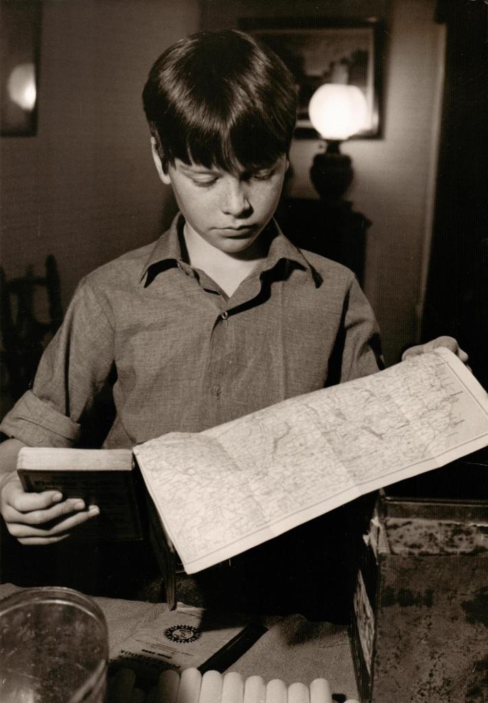 Simon West as John Walker studying the chart at Holly Howe before the voyage.